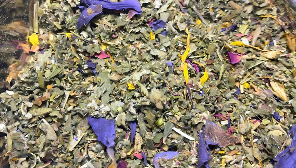 A close up of a colourful herbal smoking blend with blue lotus petals, rose and calendula